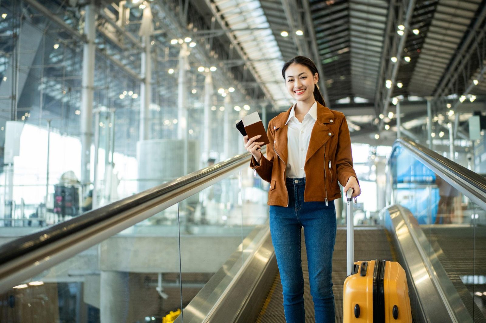 Indian woman checking passport and travel documents at an international airport.