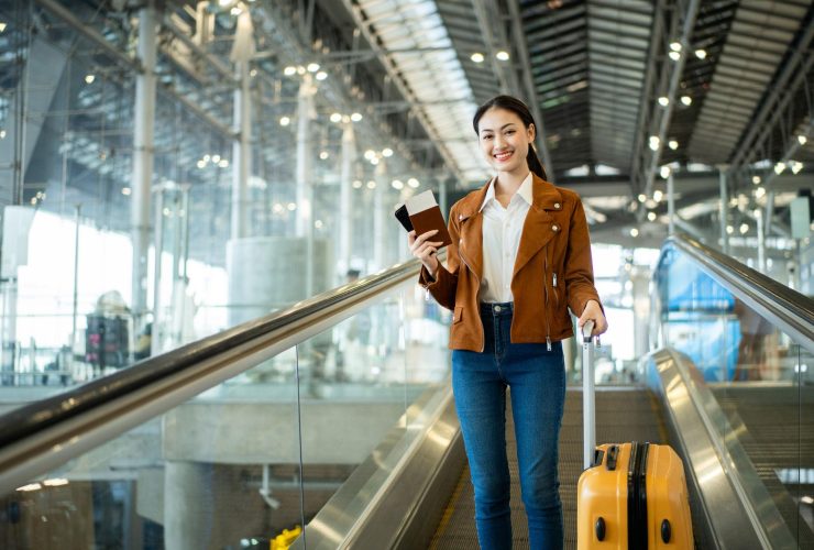 Indian woman checking passport and travel documents at an international airport.