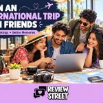 Four friends planning an international trip with a laptop and map, with the ReviewStreet logo in the footer.
